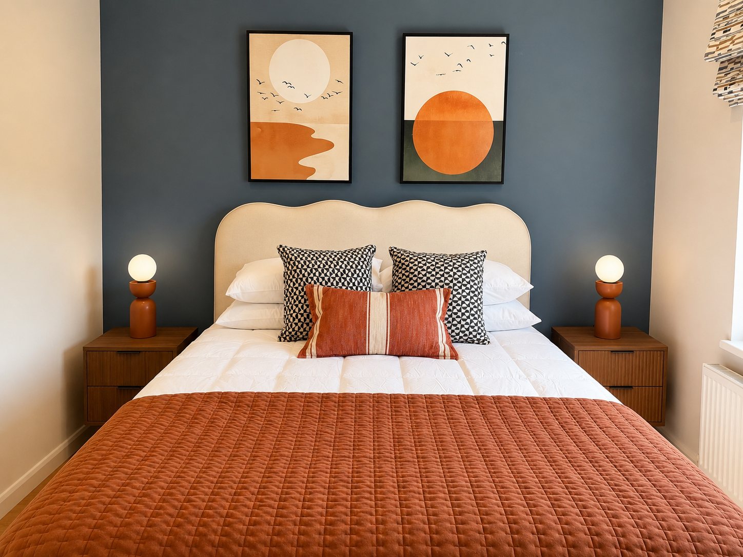 Double bedroom with blue feature wall and warm rust throw